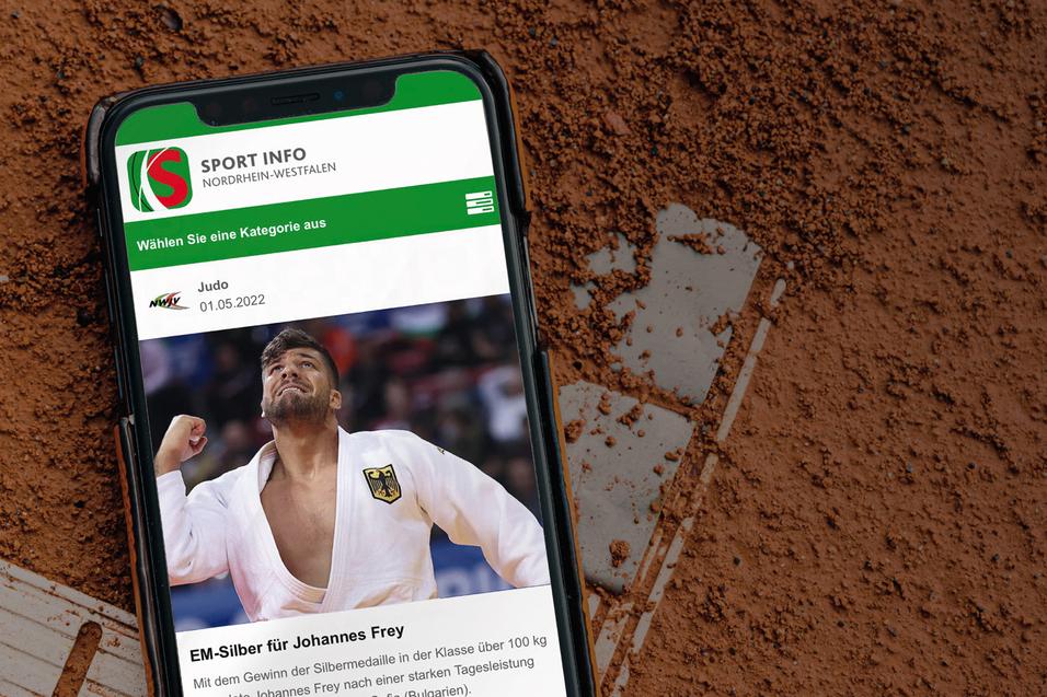 Smartphone auf einem Sandplatz mit einer Sport-Nachricht &uuml;ber Johannes Frey und dessen EM-Silbermedaille.